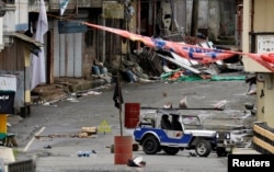 FILE - An Islamic State flag is seen pitched in an oil barrel during fighting last year between IS-affiliated Maute rebels and government forces in Marawi City, southern Philippines May 29, 2017.