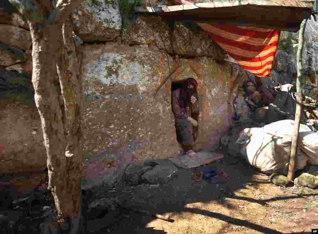 Nadia, 53, steps out of an underground Roman tomb used as shelter from shelling and airstrikes, Jabal al-Zaweya, Idlib province, Syria, Feb. 28, 2013.