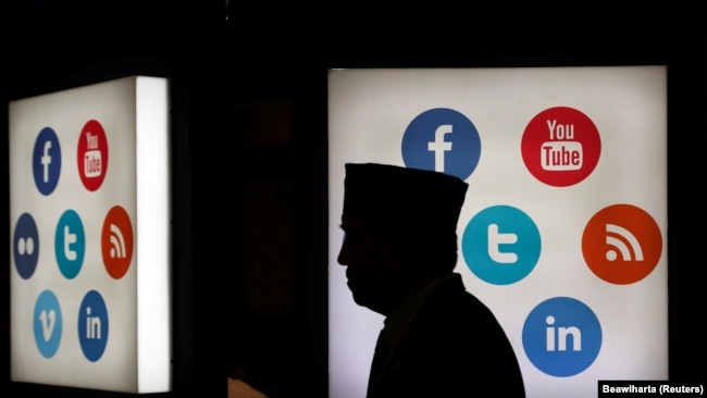 Seorang pria berjalan melintas di depan logo media sosial di Jakarta Convention Center, Jakarta,16 Mei 2016. (Foto: REUTERS/Beawiharta)