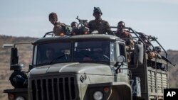 FILE - Ethiopian government soldiers ride in the back of a truck on a road near Agula, north of Mekele, in the Tigray region of northern Ethiopia, May 8, 2021.