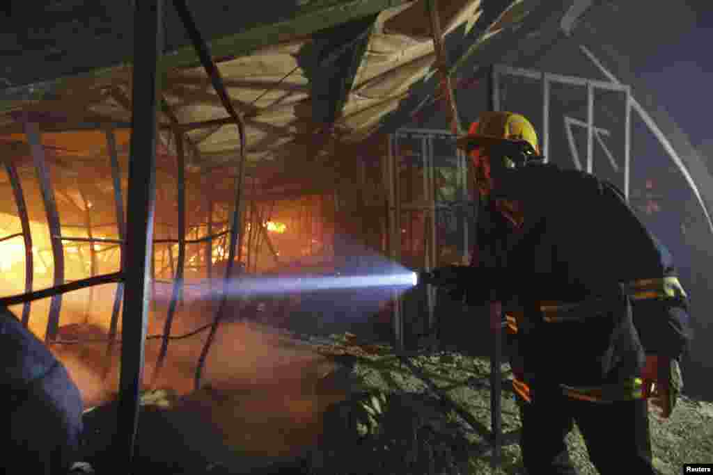 Seorang petugas pemadam kebakaran memeriksa sebuah pabrik garmen yang terbakar di Gazipur, Bangladesh (9/10).