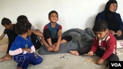 Iraqi refugee children who fled IS with their families playing on the concrete floor of their new home in a camp outside Makhmour, Iraq, April 11, 2016. (S. Behn/VOA)