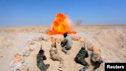 Shi'ite fighters, who have joined the Iraqi army to fight against militants of the Islamic State, formerly known as the Islamic State of Iraq and the Levant (ISIL), take part in field training in the desert in the province of Najaf, September 16, 2014. RE