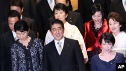 Perdana Menteri Jepang Shinzo Abe bersama para perempuan yang menjadi menteri: Menteri Perdagangan Yuko Obuchi (kiri bawah), Menteri Dalam Negeri Sanae Takaichi (kanan bawah), Menteri Pemberdayaan Perempuan Haruko Arimura (di belakang Abe), Menteri Urusan Warga Jepang yang Ditahan Korea Utara Eriko Yamatani, (atas, kedua dari kanan), dan Menteri Kehakiman Midori Matsushima. (AP/Eugene Hoshiko)