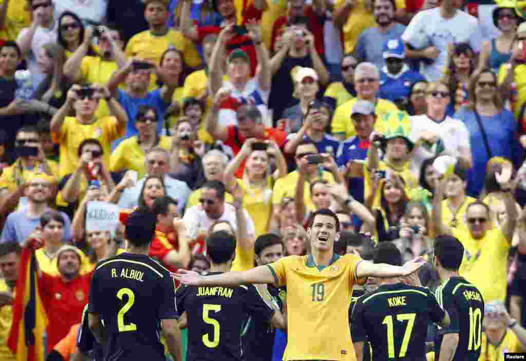 آسٹریلیا کے مک گووان اسپین کے طرف سے کیے جانے والے گول پر افسردہ ہیں جبکہ اسپین کے کھلاڑی خوشی کا اظہار کر رہے ہیں