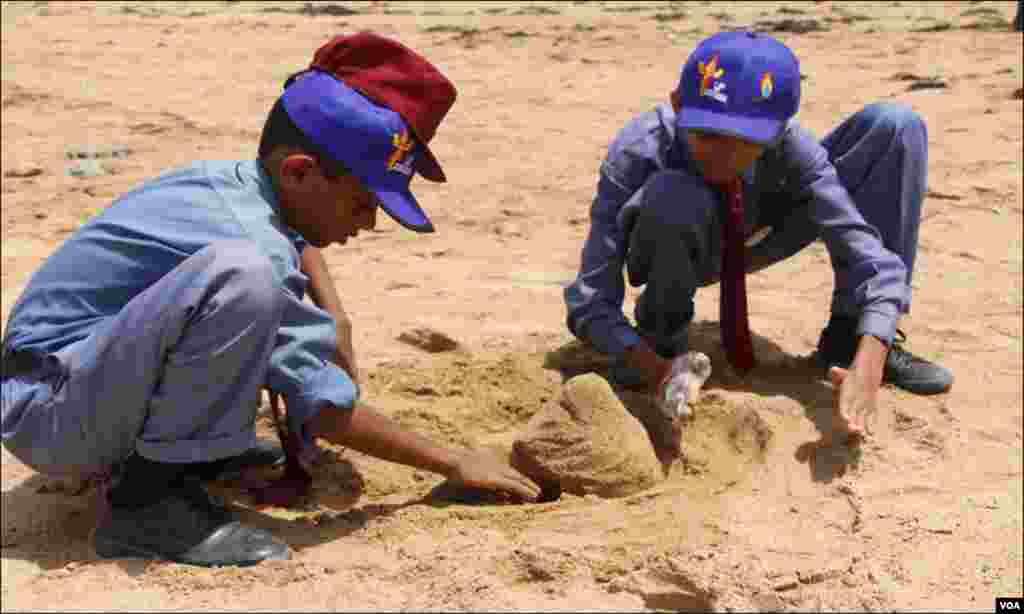 کراچی: اسکول کے دو طلبہ سمندری ریت سے کچھوہ بنانے میں مگن