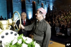 FILE - Kurdish president Massud Barzani, right, and Iraqi President Jalal Talabani open a ceremonial valve during an event to celebrate the start of oil exports from the autonomous region of Kurdistan, in the northern Kurdish city of Erbil, June 1, 2009.