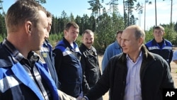 Russian Prime Minister Vladimir Putin, right, meets with employees of the Portovaya gas compressor station outside Vyborg, some 170 km northwest from St. Petersburg, Russia, Sept. 6, 2011.