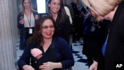 Sen. Tammy Duckworth, D-Ill., left, carries her baby Maile Pearl Bowlsbey as she heads to the Senate floor to vote, and is greeted by Sen. Claire McCaskill, D-Mo., at right, on Capitol Hill, Thursday, April 19, 2018 in Washington. (AP Photo/Alex Brandon)