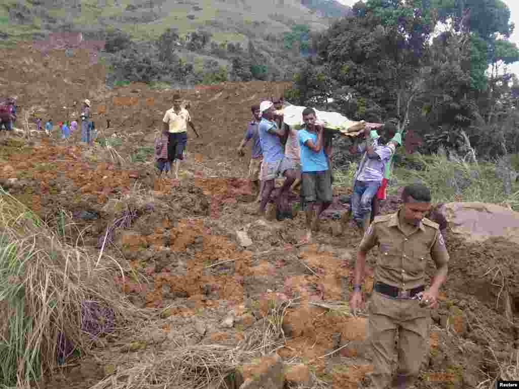 Villagers carry the body of a landslide victim at the Koslanda tea plantation&nbsp;in Badulla, about 220 kilometers east of Colombo, Sri Lanka, Oct. 29, 2014. 