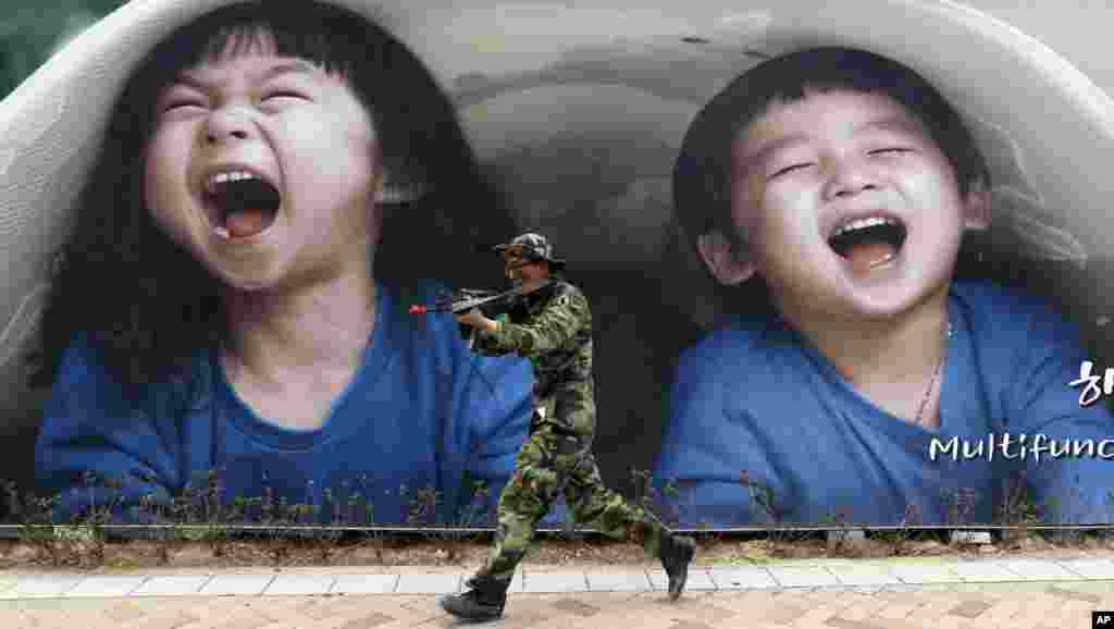 A South Korean soldier holding his machine gun runs in front of an advertisement board during an anti-terror drills at Government Complex in Sejong, south of Seoul, South Korea, April 17, 2013.