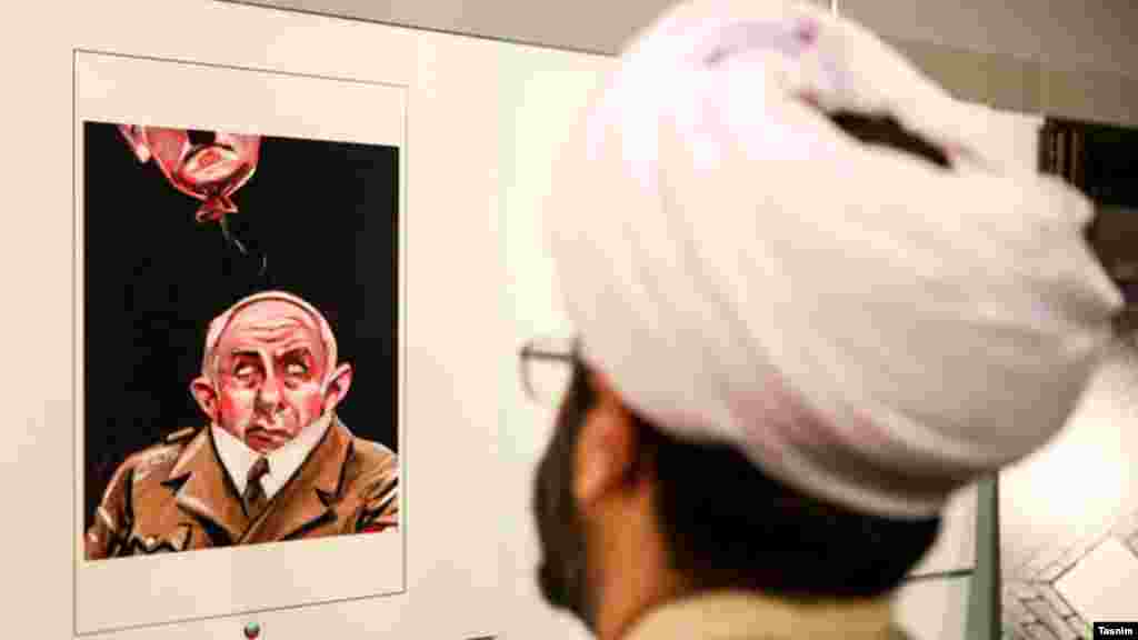 یک روحانی در دومین نمایشگاه بین‌المللی کارتون و کاریکاتور هولوکاست که عملا به انعکاس آثاری در نفی و تمسخر هولوکاست می پردازد.