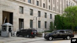 A motorcade for Attorney General William Barr arrives at the Department of Justice, April 17, 2019, in Washington. 