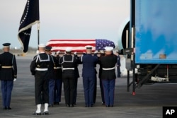 The flag-draped casket of former president George H.W. Bush is carried by a joint services military honor guard, Dec. 5, 2018, at Ellington Field in Houston, Texas.