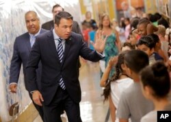 Former U.S. Rep. Michael Grimm looks for a high-five from kids after voting at his polling site in a school in the Staten Island borough of New York, June 26, 2018.