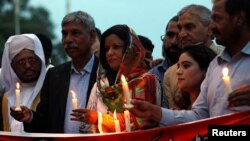 People hold candles to pay respects to the victims of Sri Lanka's serial bomb blasts, in Islamabad, Pakistan, April 24, 2019.