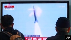 People watch TV reporting North Korea's missile test at Seoul Railway Station in Seoul, South Korea, March 4, 2014. 