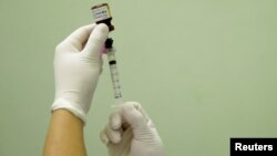 FILE - A health agent prepares a vaccine during a campaign of vaccination against yellow fever in Rio de Janeiro, Brazil, March 25, 2017.