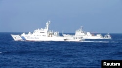 Chinese marine surveillance ship Haijian No. 51 (R) cruises next to a Japan Coast Guard patrol ship, Akaishi, in the East China Sea near the disputed isles known as Senkaku isles in Japan and Diaoyu islands in China, Feb. 4, 2013.