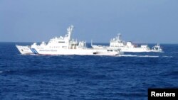 日本巡邏船（左）與中國海監船（右）在有爭議島嶼水域對峙並行。（路透社圖片 2013年2月由日本海岸警衛隊發表）