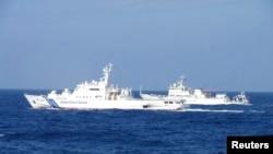 Chinese marine surveillance ship Haijian No. 51 (R) cruises next to a Japan Coast Guard patrol ship, Akaishi, in the East China Sea near the disputed isles known as Senkaku isles in Japan and Diaoyu islands in China, February 4, 2013.