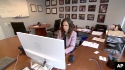 In this Dec. 4, 2017, image made from a video, Eleanor McManus works at her desk at Trident DMG, the Washington public relations firm she co-founded.