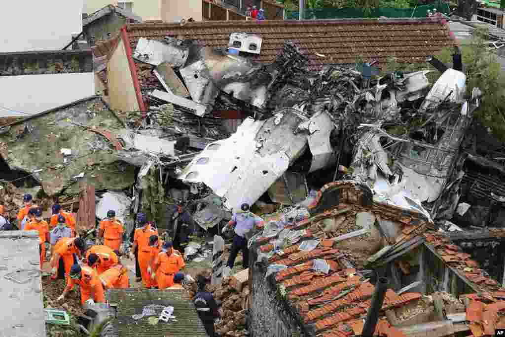 Rescue workers survey the wreckage of TransAsia Airways Flight GE222 on the Taiwanese island of Penghu, July 24, 2014.