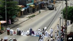 Women pray as they face off against soldiers in an unauthorized protest calling for Laurent Gbagbo to step down, Abidjan, Ivory Coast. (AP/Rebecca Blackwell)