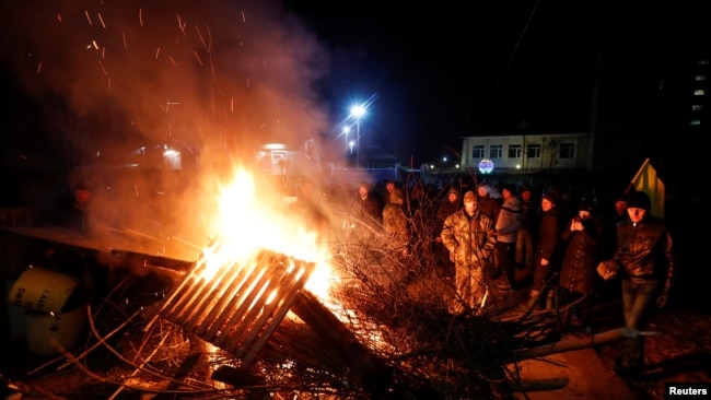 在乌克兰中部新桑扎里地区，示威者放火并竖起路障，抗议一架载有从遭受新型冠状病毒袭击的中国湖北省撤离人员的飞机的到来（2020年2月20日）。