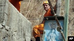 A rescue worker looks on outside the Minesadco mine in Portovelo, southern Ecuador. A tunnel collapsed in the gold mine, operated by the Ecuadorean company Minesadco, trapping four miners 490 feet, some 150 meters, underground, 16 Oct 2010