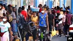 Haitianos, muchos de los cuales han estado esperando hasta un año en México para que se procesen sus solicitudes de asilo, hacen fila para recibir remesas de familiares frente a la tienda Salinas y Rocha, el 3 de septiembre de 2021, en Tapachula, México.