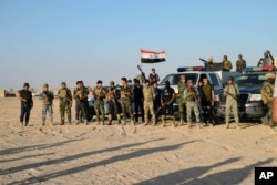 FILE - Sunni volunteer fighters are deployed in the eastern suburbs of Ramadi, the capital of Iraq's Anbar province, 70 miles (115 kilometers) west of Baghdad, to support the Iraqi security forces in liberating the city from Islamic State group militants, Oct. 1