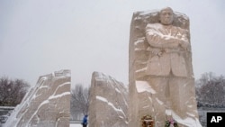 A visitor walks through the Martin Luther King, Jr. Memorial as a winter storm blows through the Washington area, Jan. 16, 2022. 