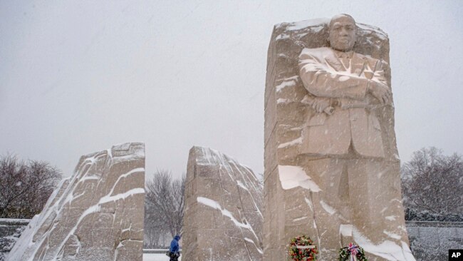 A visitor walks through the Martin Luther King, Jr. Memorial as a winter storm blows through the Washington area, Jan. 16, 2022.