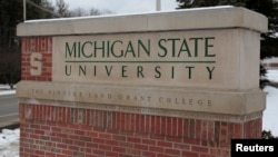 FILE: A sign for Michigan State University is seen near the campus in East Lansing, Michigan, Feb. 1, 2018. 