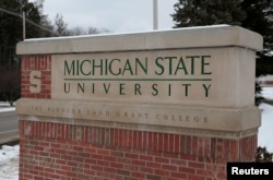 FILE: A sign for Michigan State University is seen near the campus in East Lansing, Michigan, Feb. 1, 2018.
