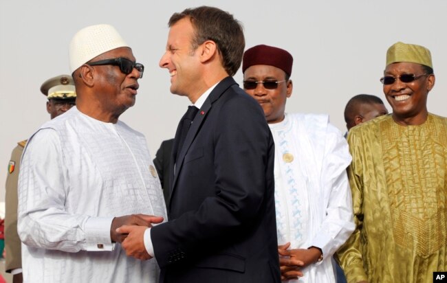 In this pictured taken July 2, 2018, French President Emmanuel Macron delivers a speech during a press conference ahead of a G5 Sahel force meeting while (left to right) Mauritania President Mohamed Ould Abdel Aziz, Niger President Mahamadou Issoufou, Mali President Ibrahim Boubacar Keita, Chad President Idriss Deby, Burkina Faso President Roch Marc Christian Kabore look on, in Nouakchott, Mauritania.