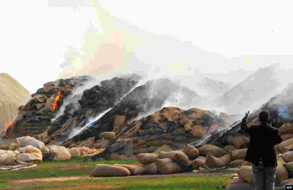 Sacks of wheat burn following air strikes by Syrian regime forces in the town of Ras al-Ain near the border with Turkey on November 16, 2012. 