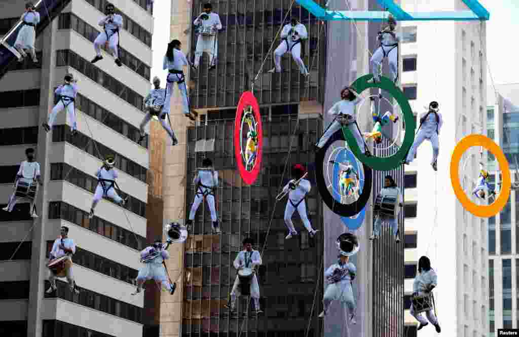 Acrobats on Olympics rings and musicians perform as the Olympic torch is relayed along Paulista Avenue in Sao Paulo&#39;s financial center, Brazil.