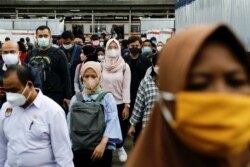 Para calon penumpang mengenakan masker, berjalan menuju platforn kereta komuter pada jam sibuk sore hari, di tengah merebaknya varian omicron di Jakarta, 3 Januari 2022. (REUTERS/Willy Kurniawan)