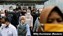Penumpang yang memakai masker berdiri di dalam kereta komuter pada jam sibuk di sore hari saat varian omicron terus menyebar di Jakarta, 3 Januari 2022. (Foto: REUTERS/Willy Kurniawan)