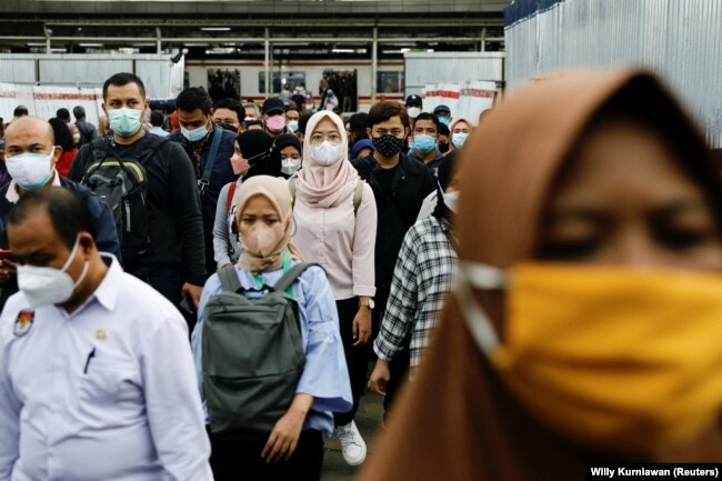 Para calon penumpang mengenakan masker, berjalan menuju platforn kereta komuter pada jam sibuk sore hari, di tengah merebaknya varian omicron di Jakarta, 3 Januari 2022. (REUTERS/Willy Kurniawan)