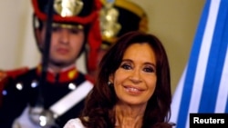 FILE - Argentina's President Cristina Fernandez de Kirchner smiles during a ceremony on her last day in office at the Casa Rosada Presidential Palace in Buenos Aires, Argentina, Dec. 9, 2015. 