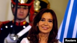 FILE - Argentina's President Cristina Fernandez de Kirchner smiles during a ceremony on her last day in office at the Casa Rosada Presidential Palace in Buenos Aires, Argentina, Dec. 9, 2015. 
