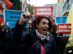 A woman shouts slogans outside the headquarters of the Cumhuriyet newspaper in Istanbul, Tuesday, Nov. 1, 2016.