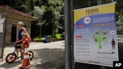 FILE - A banner explaining how the yellow fever is transmitted hangs at the entrance of a park in Sao Paulo, Brazil, Jan. 16, 2018.