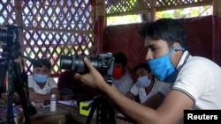 Seorang instruktur memberikan pelatihan fotografi di kamp pengungsi Rohingya di Bangladesh (foto: Reuters).