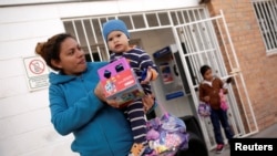 Una migrante centroamericana y su hijo son devueltos a México para esperar su audiencia en una corte de inmigración que decidirá su petición de asilo en EE.UU. Ciudad Juárez, Mx. diciembre 23 de 2019. Reuters/José Luis González.