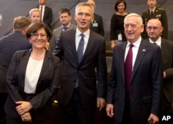 Italian Defense Minister Elisabetta Trenta, left, poses with NATO Secretary General Jens Stoltenberg, center, and U.S. Secretary for Defense Jim Mattis during a meeting of NATO defense ministers in Brussels, June 7, 2018.