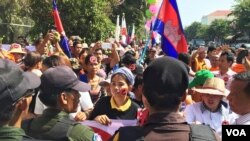 Two protesters against the controversial LANGO stand opposite the Cambodian Senate building as the bill is debated early Friday. (Robert Carmichael for VOA News)